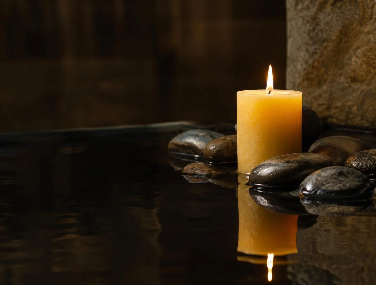Beeswax candle reflected in dark water